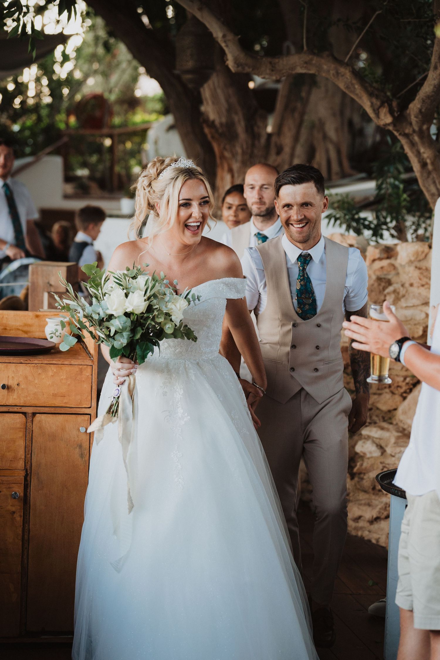 Newlyweds share a laugh during their outdoor garden wedding celebration.