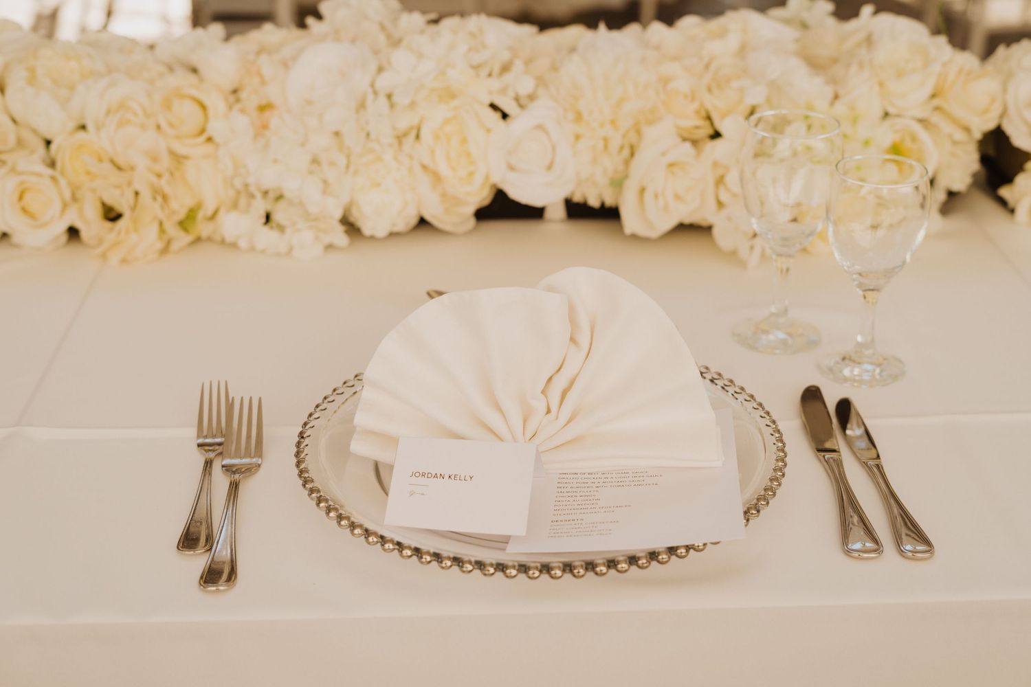White floral arrangements and elegant table settings create a romantic wedding reception atmosphere.