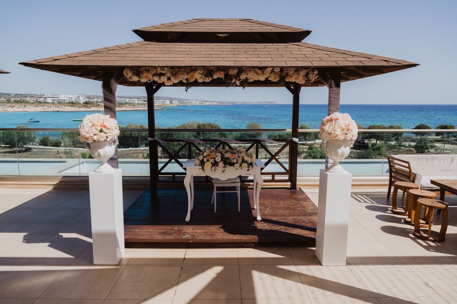 Panoramic view of wooden gazebos and deck overlooking turquoise ocean waters.