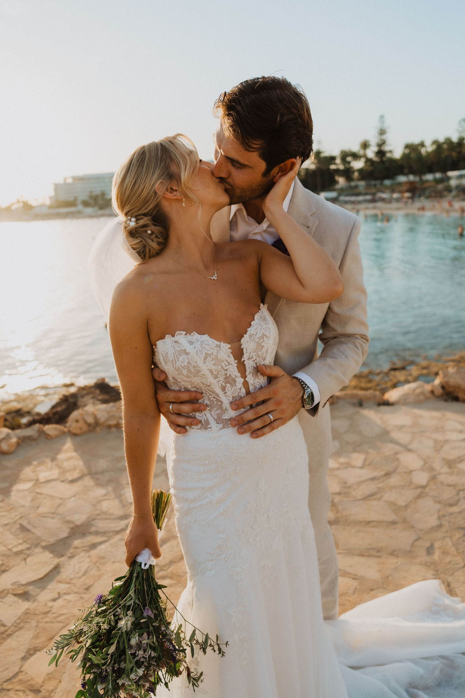Romantic beach wedding photos show intimate embraces against Mediterranean waters.