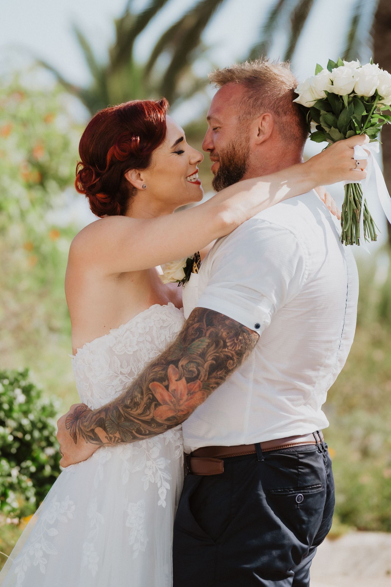 A tender embrace captured during an outdoor wedding photoshoot with white floral bouquet.