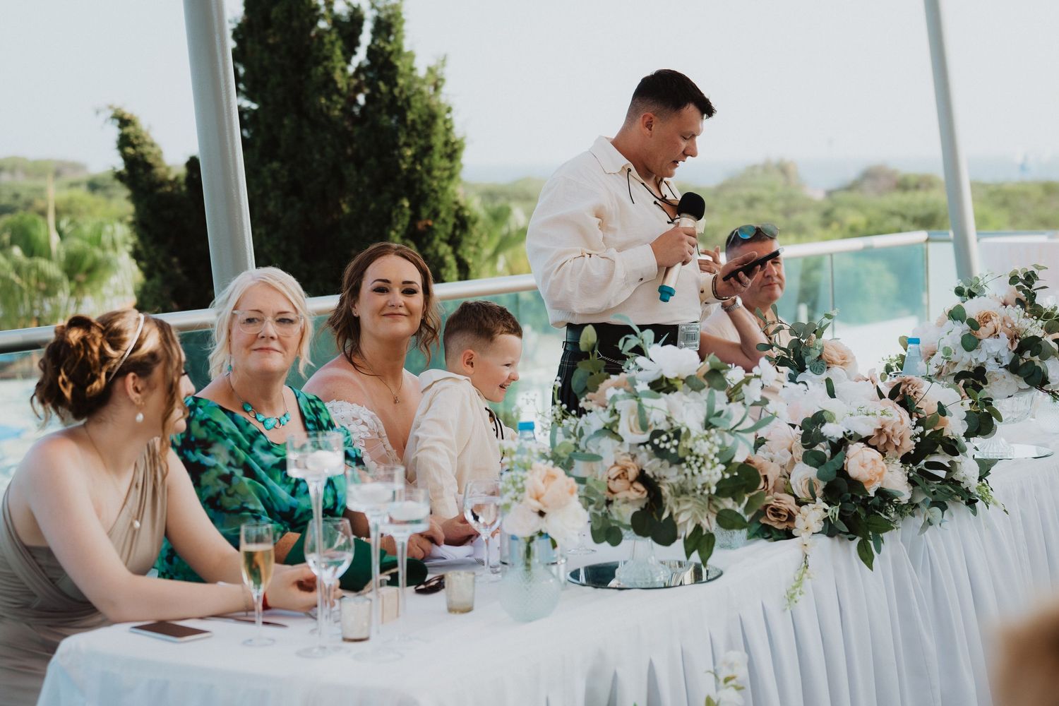 Wedding reception scene with guests seated at decorated head table.