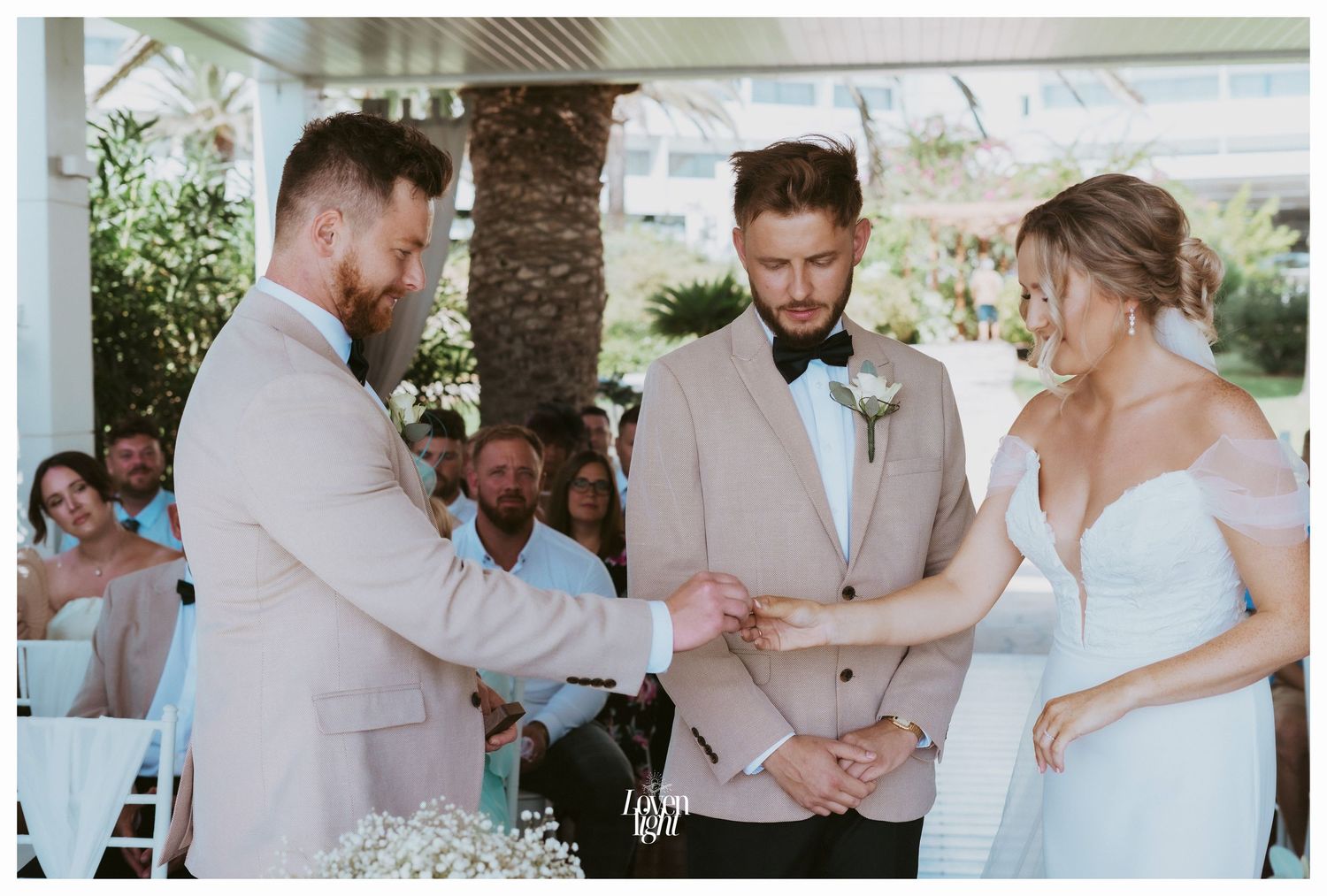 A wedding ceremony in a covered outdoor venue with white chairs and soft natural lighting.