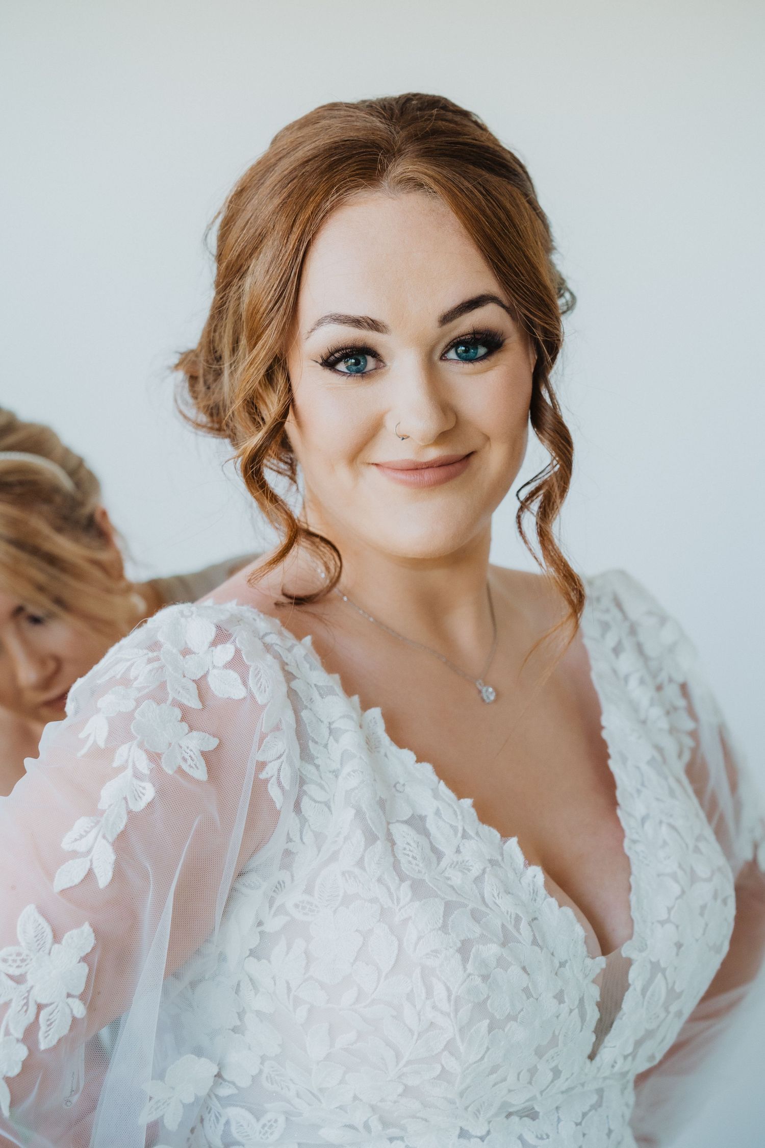Close-up portrait of bride wearing an elegant V-neck lace wedding dress with delicate details.