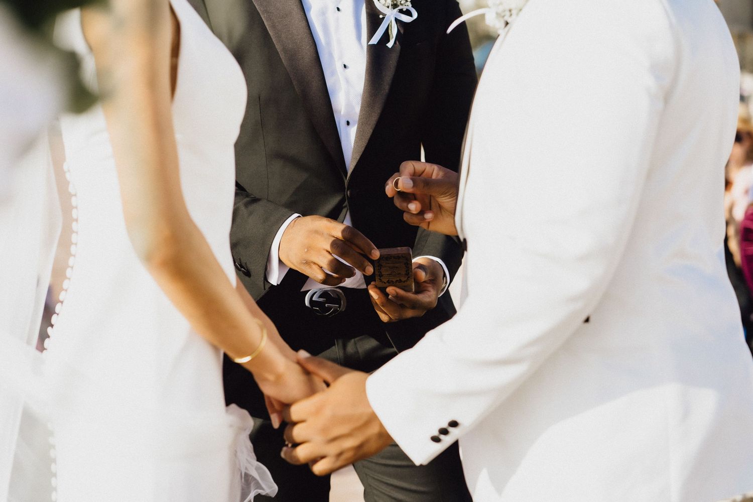 Exchange of rings during beachfront wedding ceremony.