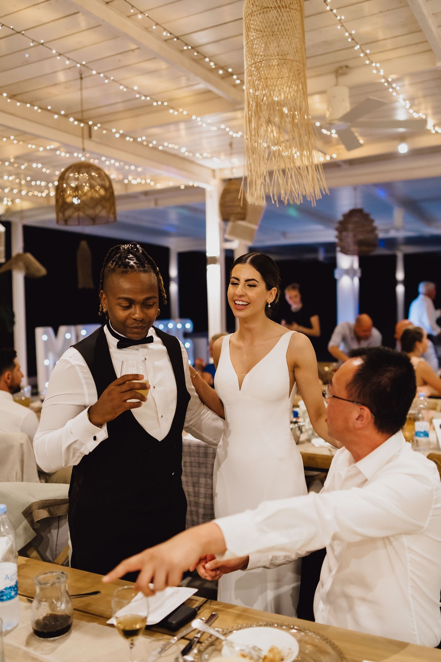 Wedding celebration dinner featuring elegant macrame decor and string lights overhead.