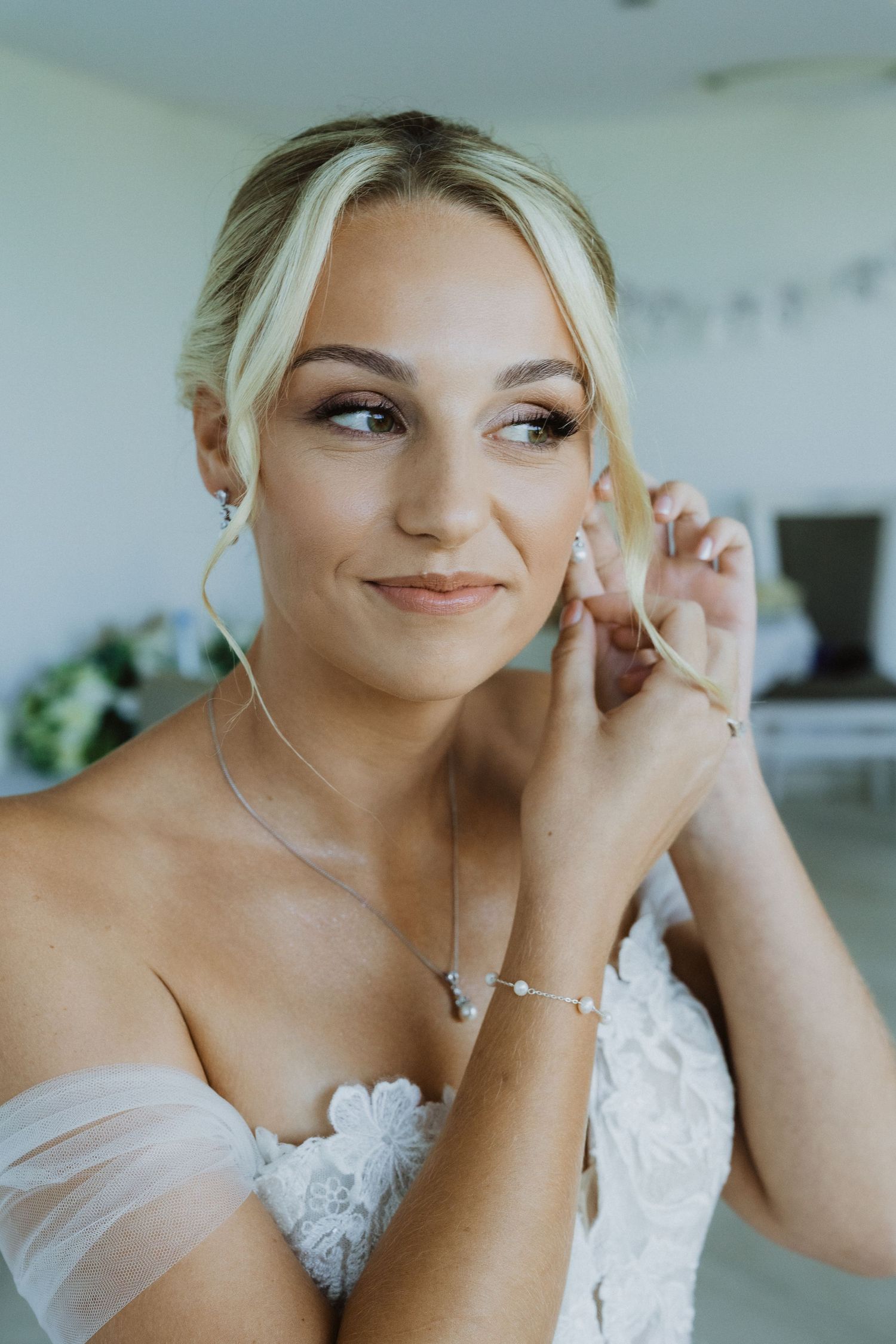 Wedding preparation moments captured in an elegant white modern setting.