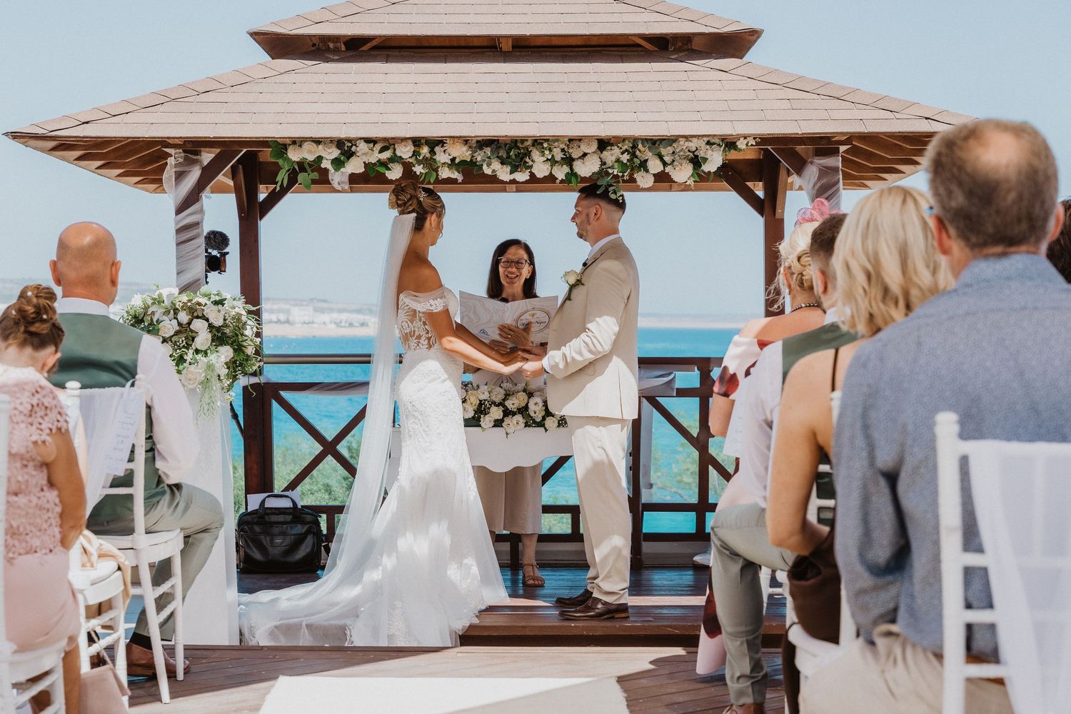 A collage of beach wedding ceremony scenes with white chairs, tropical decor, and oceanfront views.