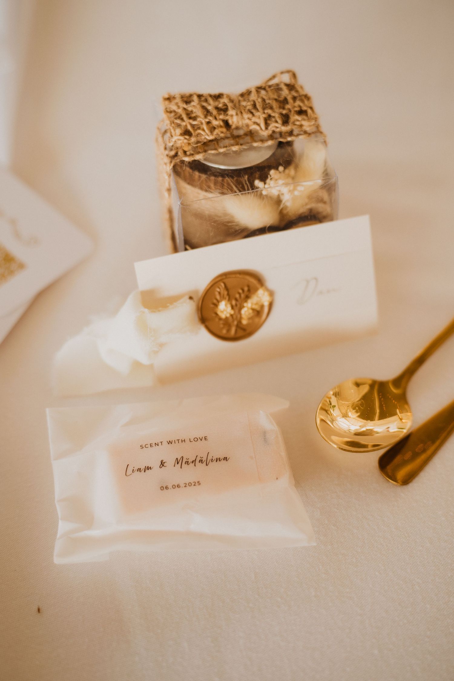 Elegant wedding favor display featuring personalized packets, gold wax seal card, and gold spoon.