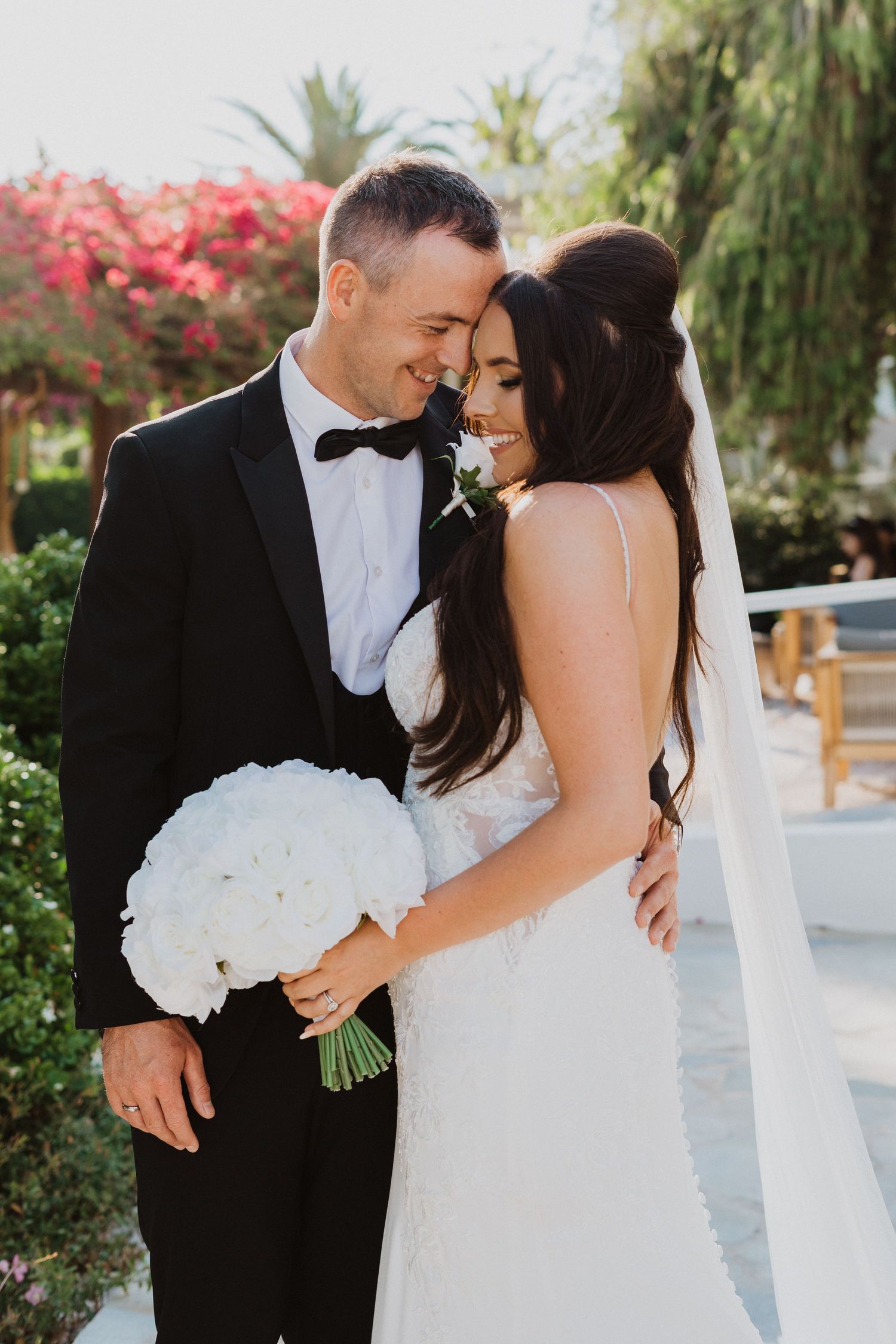 Newlyweds share tender moments during their outdoor wedding photoshoot.