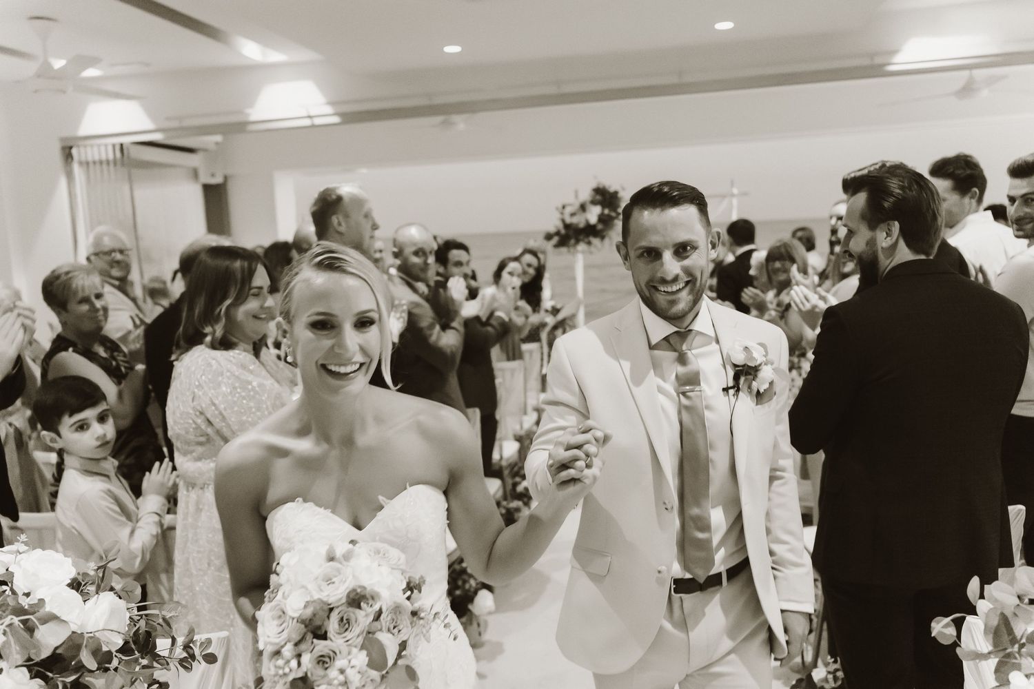 A joyous celebration at a wedding reception with guests dancing and mingling in an indoor venue.