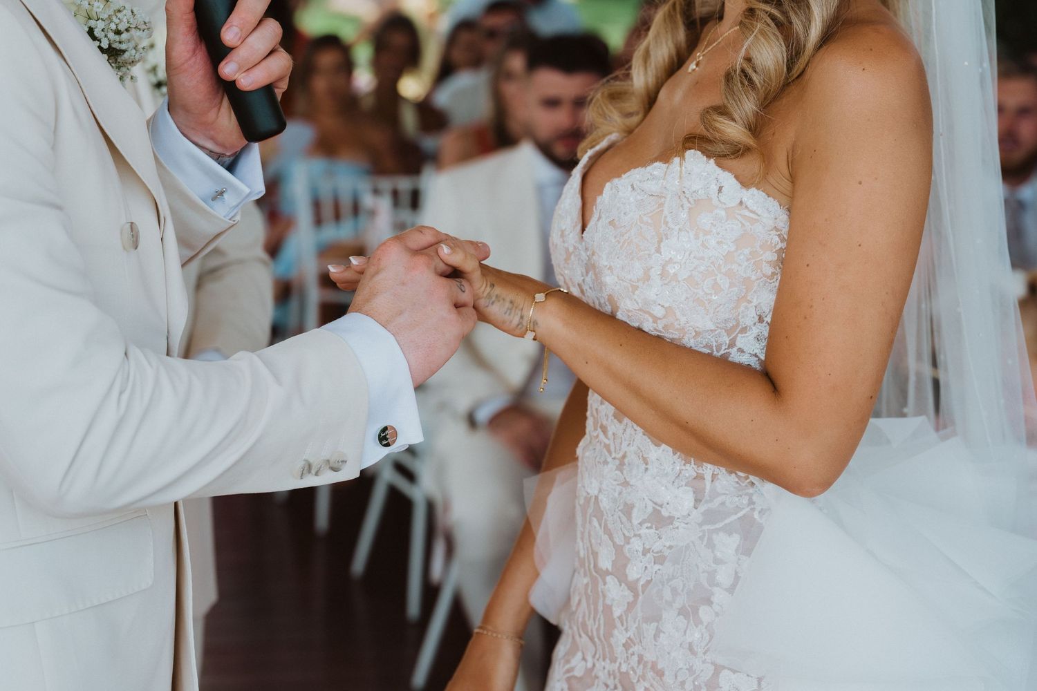 Newlyweds share their first dance at a wedding reception while guests watch and take photos in the background.