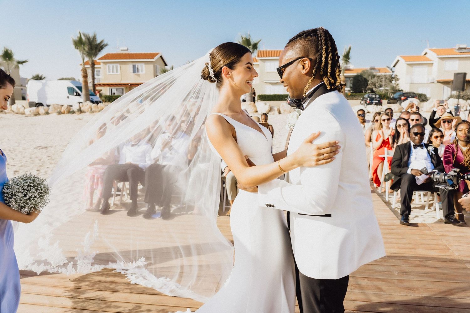 Romantic first dance moment at an oceanside wedding with guests watching.