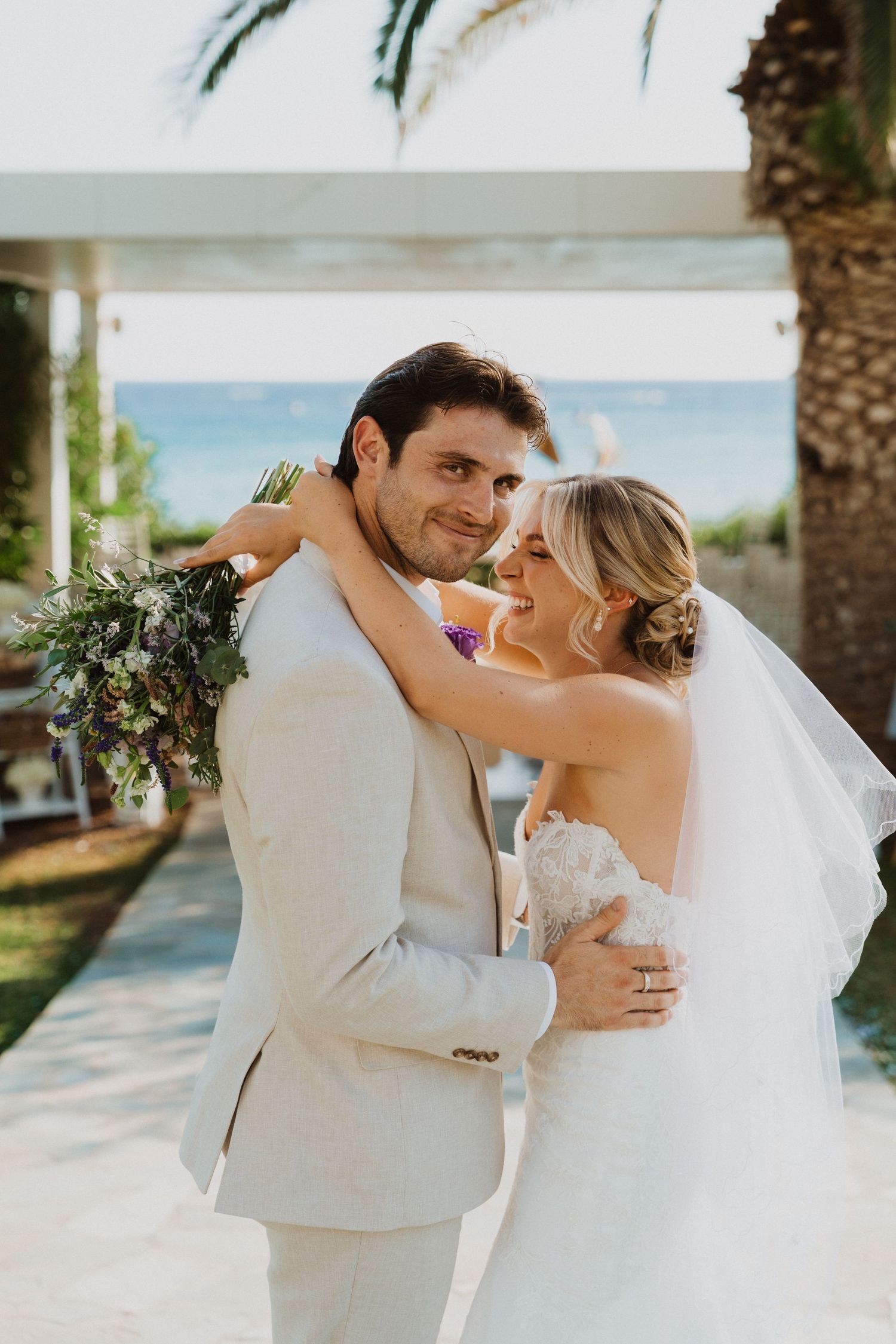 Intimate wedding portrait of couple dancing on tropical beachfront patio.