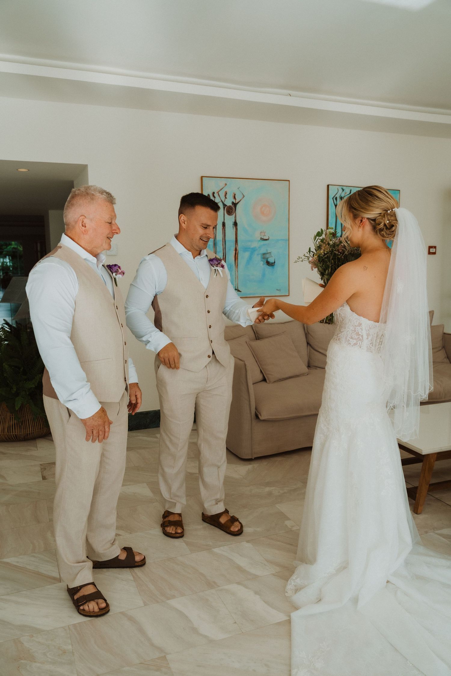 Wedding party members share touching moments before the ceremony in an elegant indoor space.