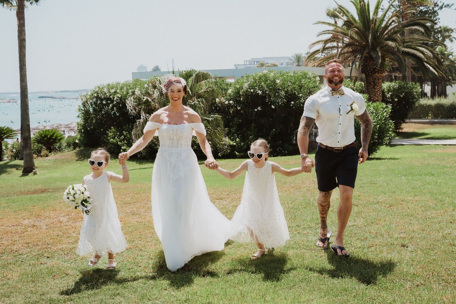 Family walks hand in hand on a seaside lawn with ocean views.