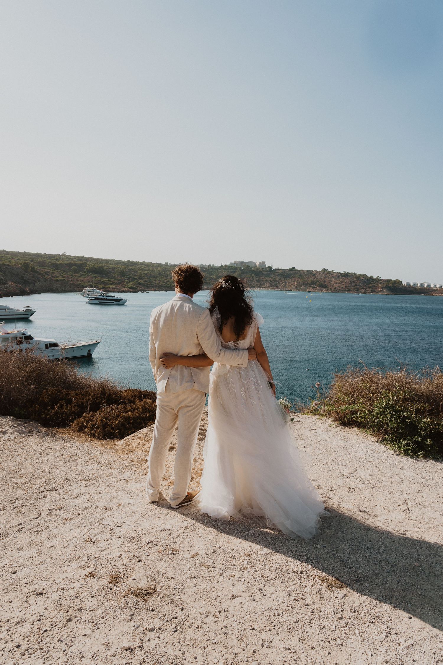 A peaceful moment as newlyweds gaze at the harbor view from a coastal vantage point.