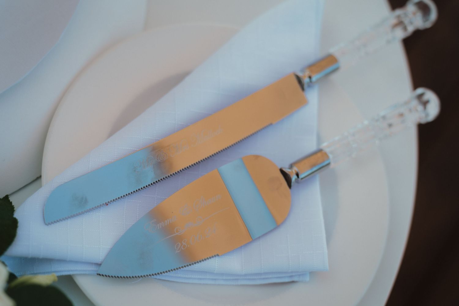 Wedding cake serving set with blue and gold handles on white napkin.