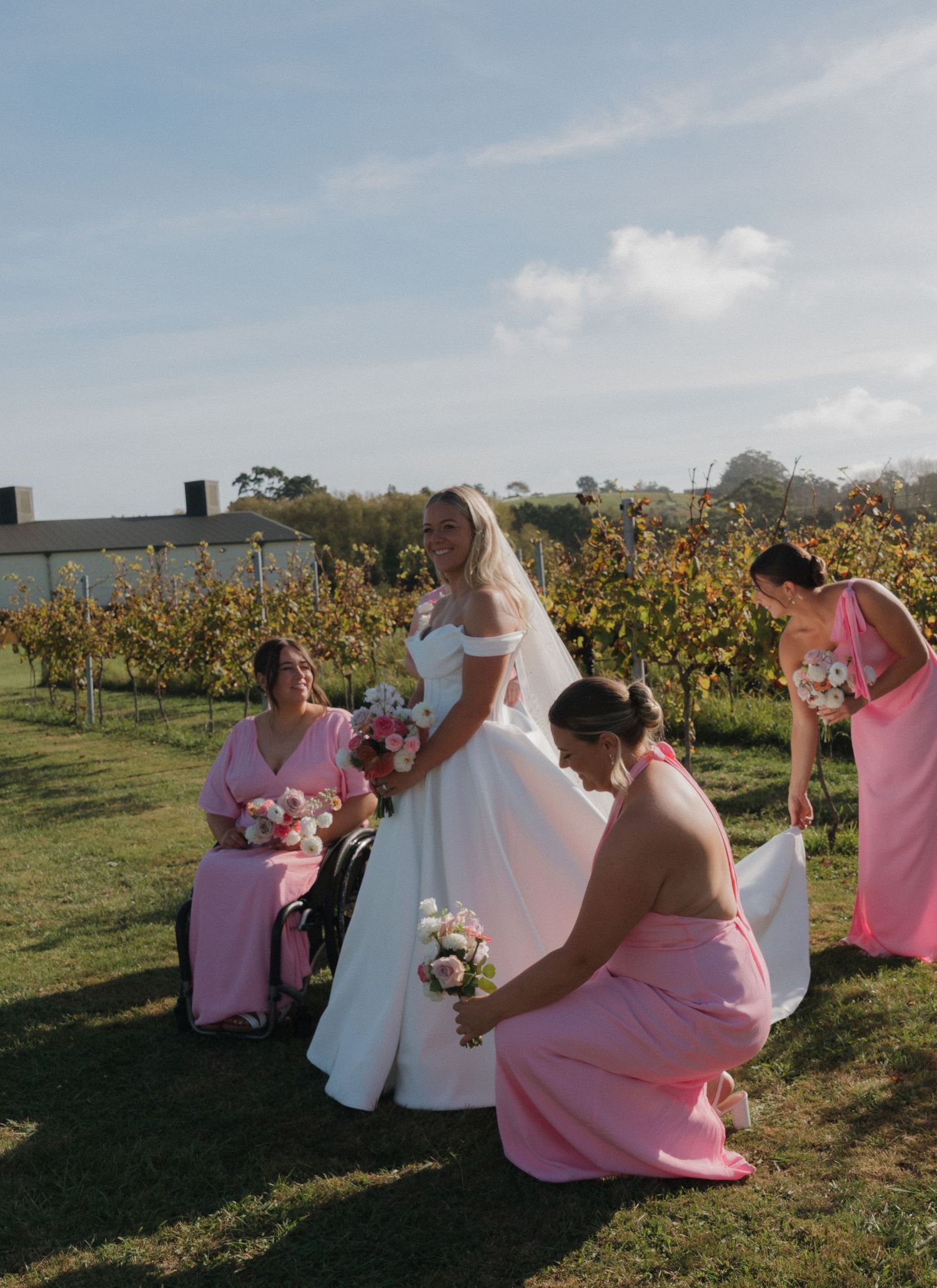 bridesmaids fixing the brides beautiful dress