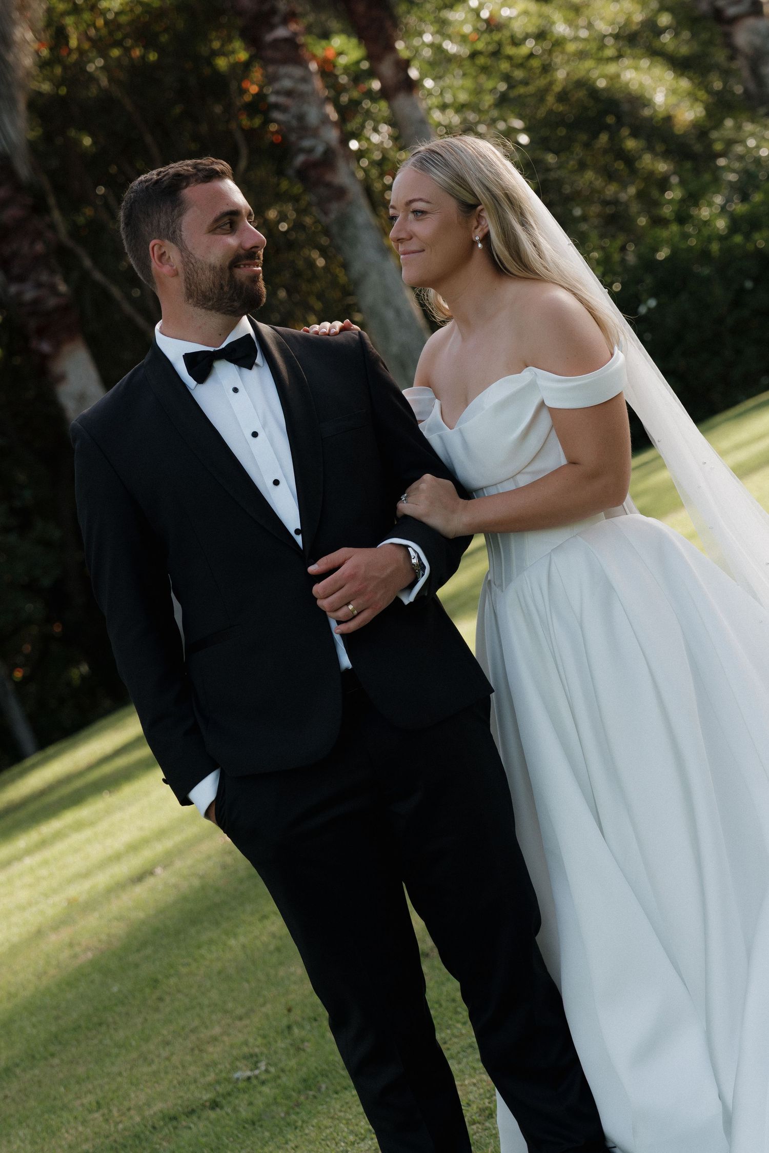 Bride and Groom glancing at each other in Auckland venue Hunting Lodge