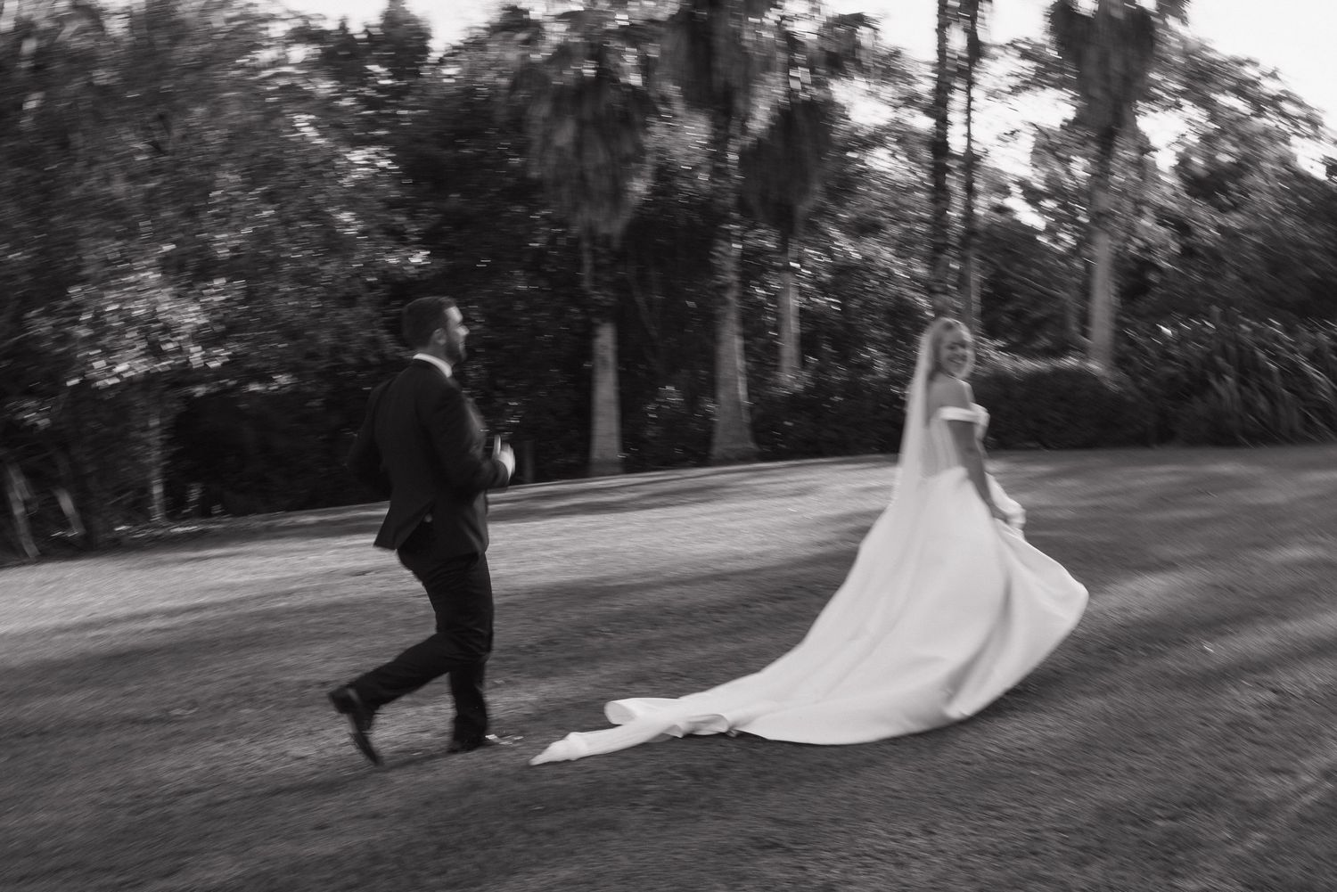 Bride and Groom playing chase in the grass creating a fun vibe