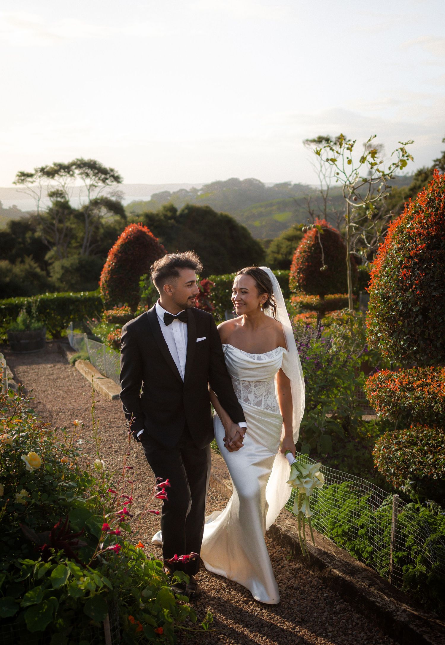 Bride and Groom walking through Mudbrick Winery