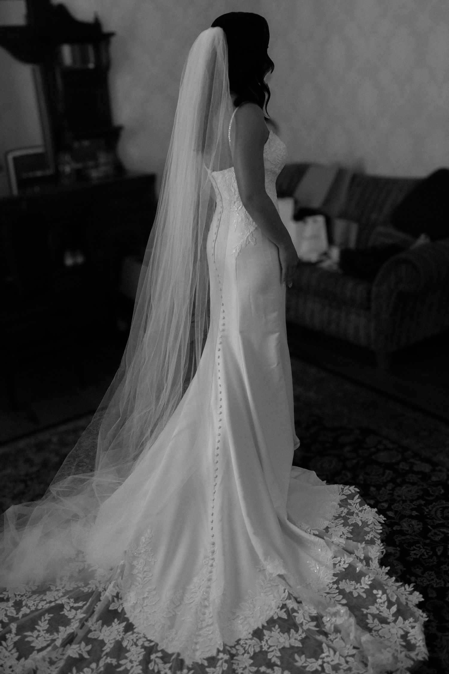 Details of brides dress and veil from the back in black and white