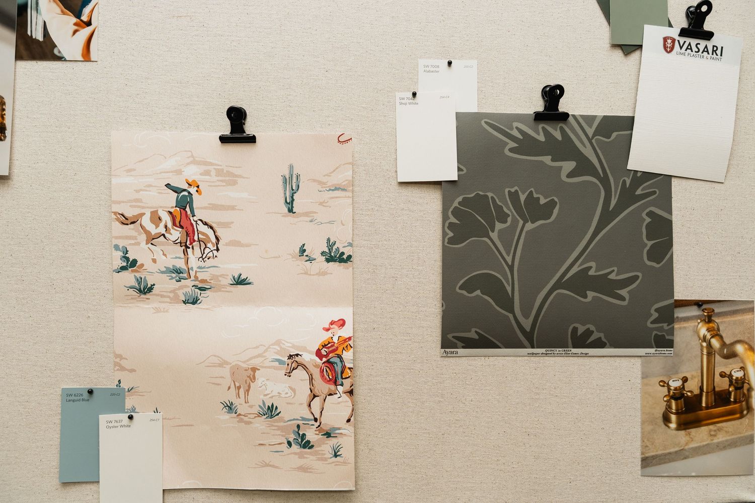 Mood board with cowboy wallpaper swatches, gray floral print, and color samples pinned to a bulletin board.