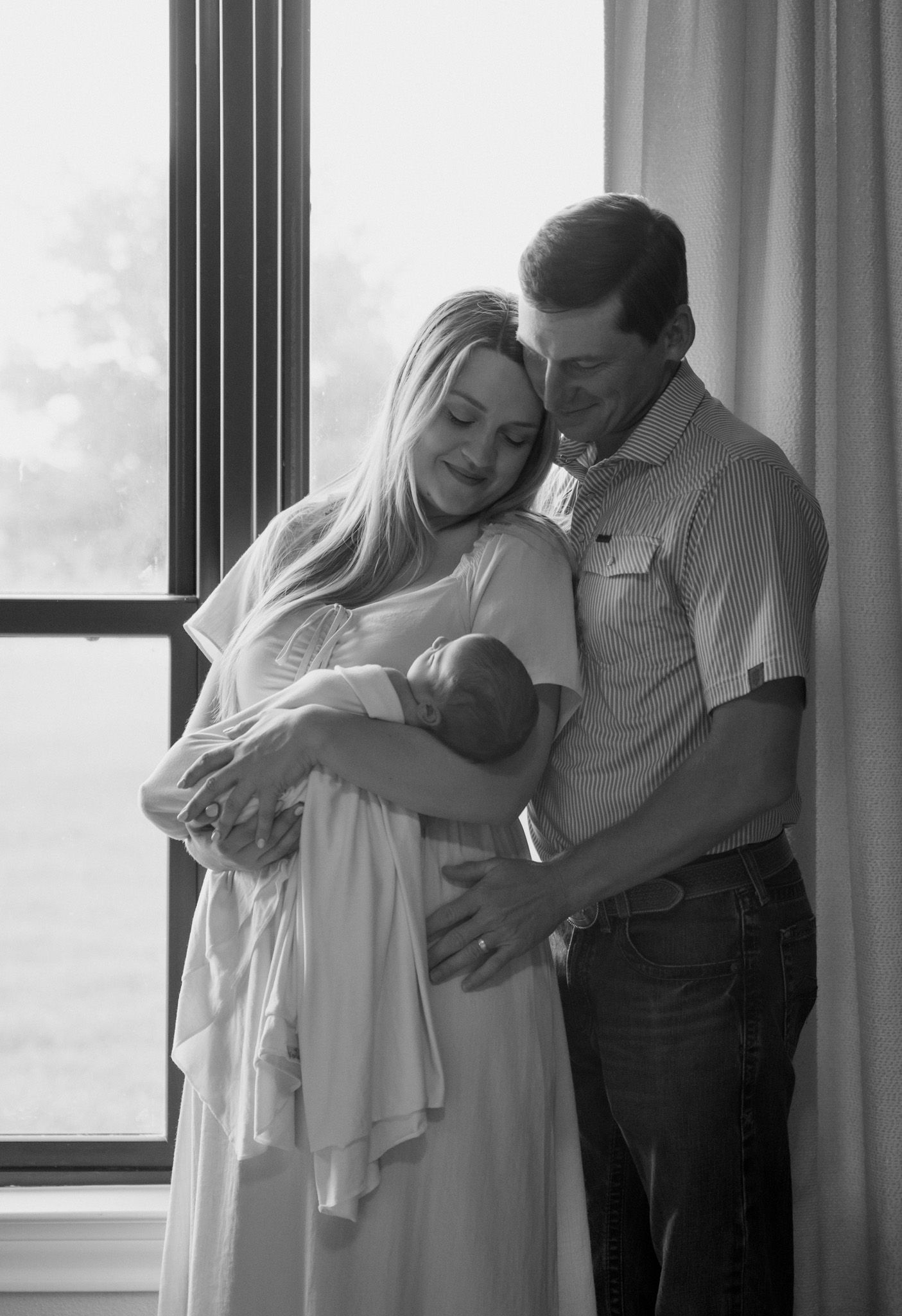 Parents holding her newborn son during an in-home session in East Bernard, Texas.