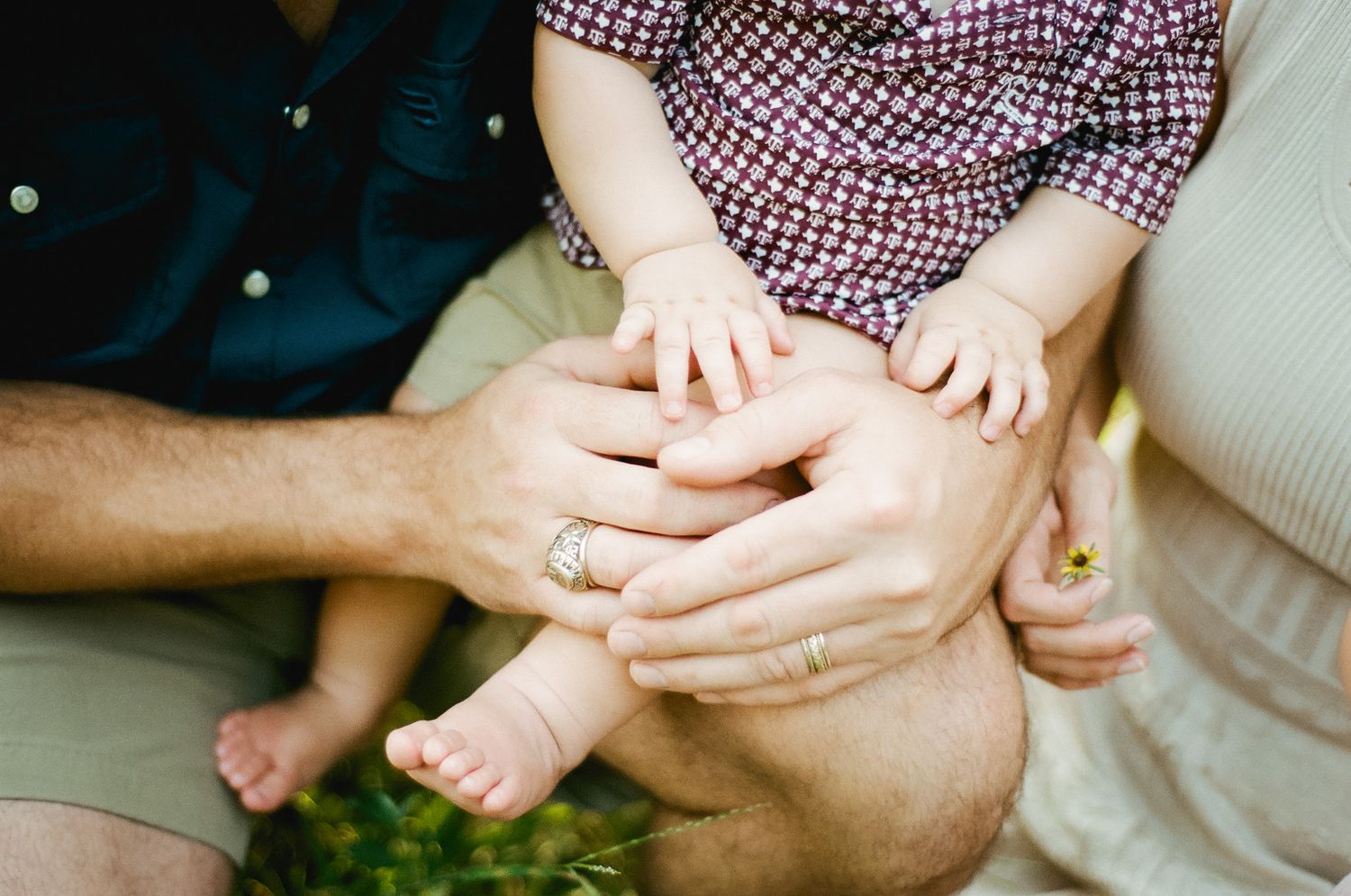 Close-up of parents and baby hands together, symbolizing family love and bonding outdoors.