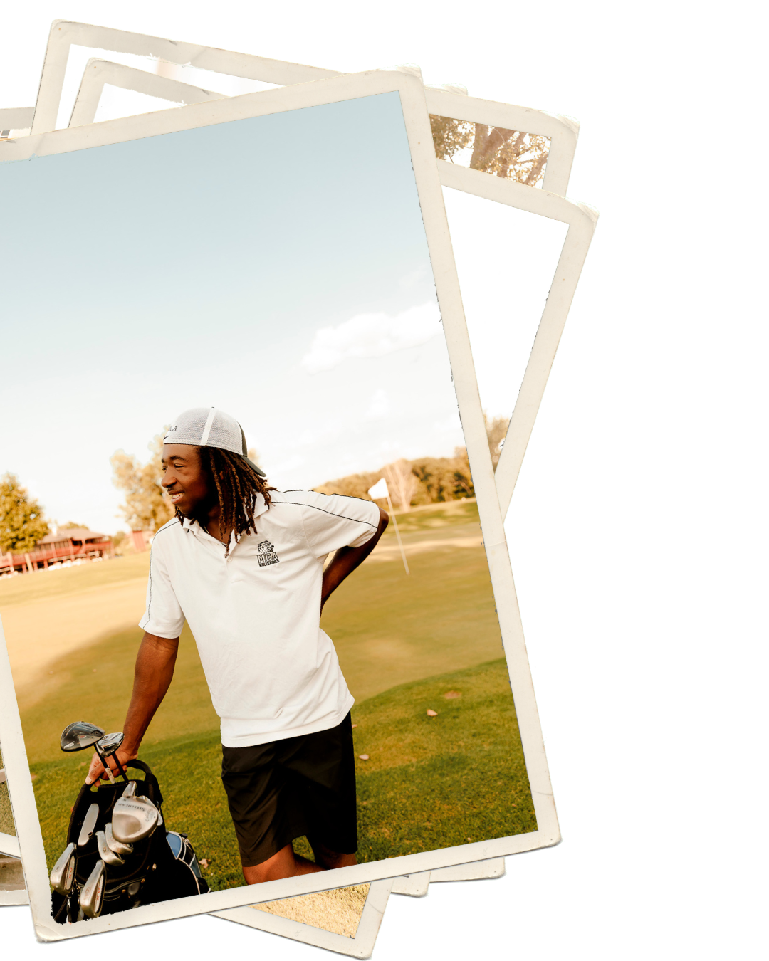 A young man with dreadlocks wearing a white polo and black shorts holds golf clubs on a sunny golf course.