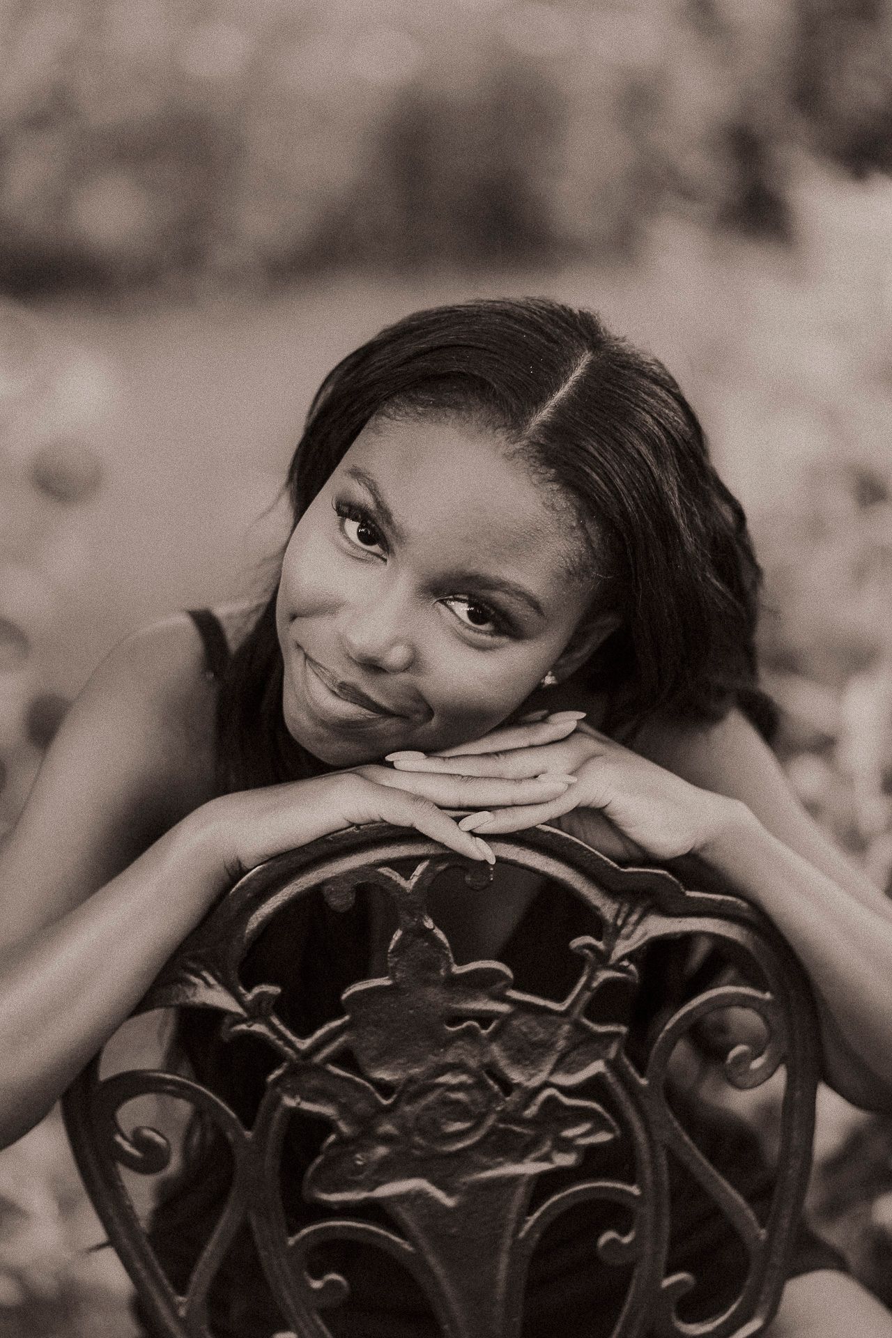 A black and white photo series shows a person posing playfully behind an ornate wrought iron railing.