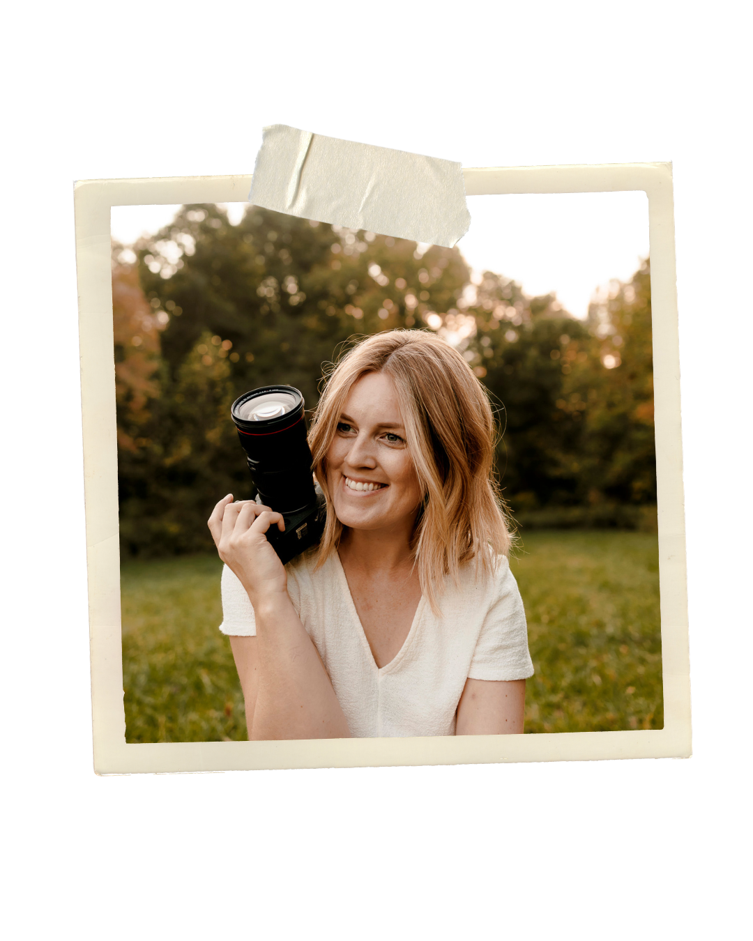 Smiling female photographer holding a DSLR camera outdoors in a green park during golden hour.