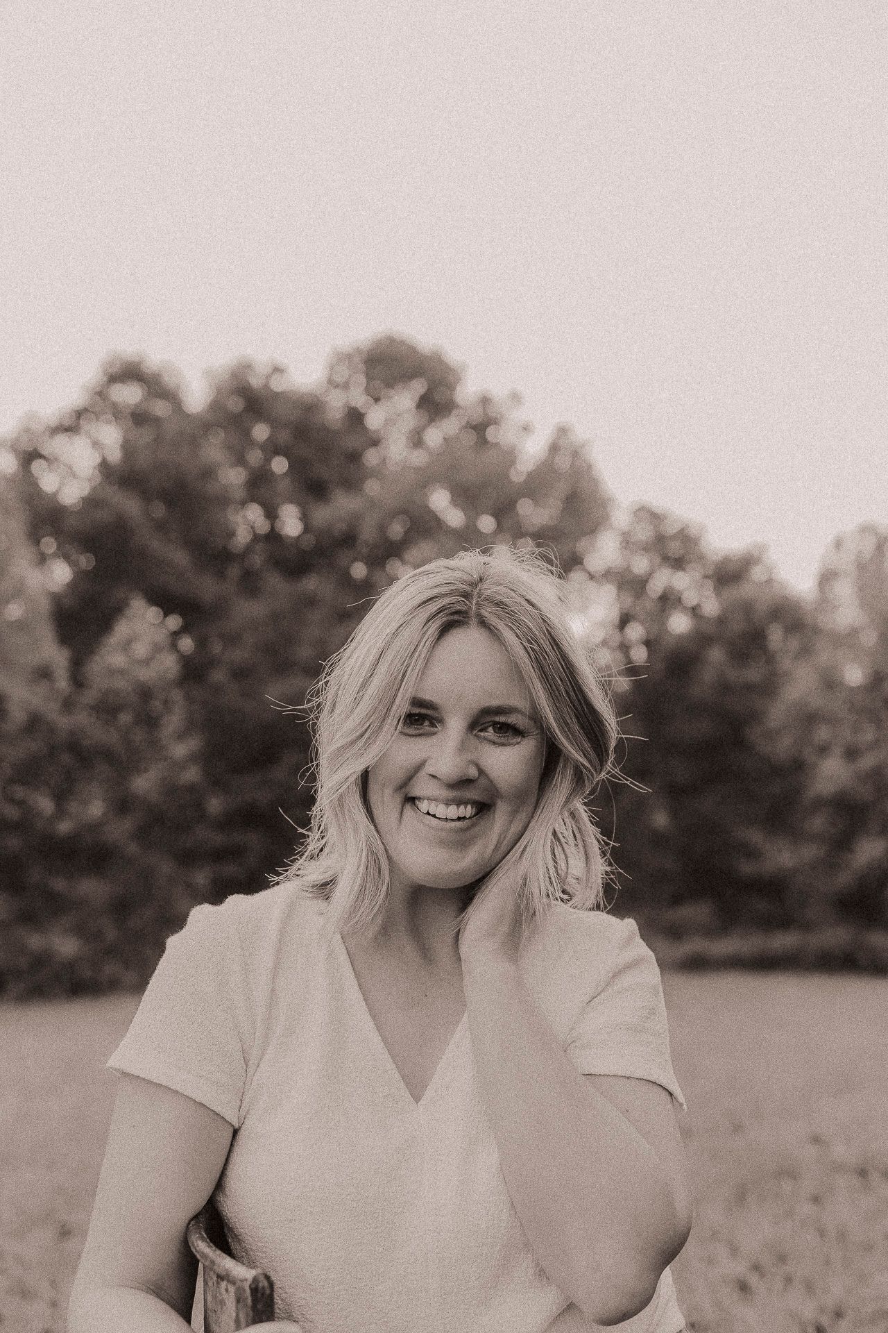 A series of black and white portraits showing joyful expressions and natural outdoor lighting in a field setting.