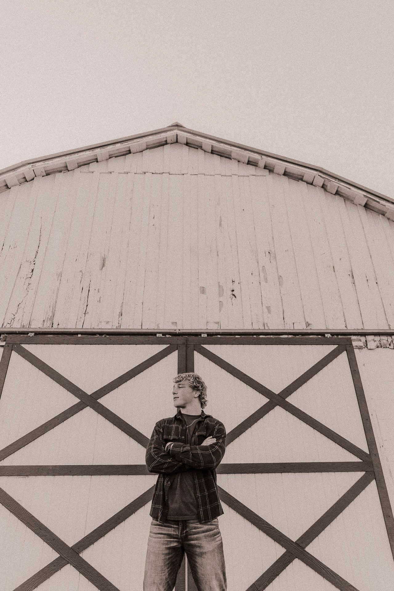 A black and white photo series showing someone standing against a white wall with diagonal cross beams in different poses.