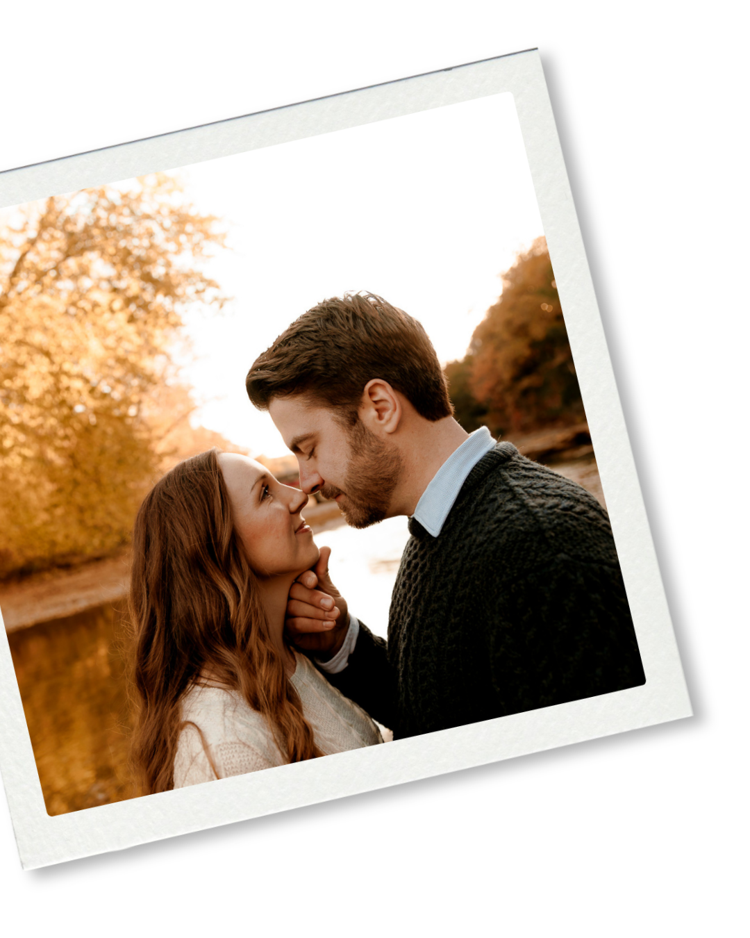 A romantic couple shares a tender kiss outdoors during golden autumn light near a serene lake.
