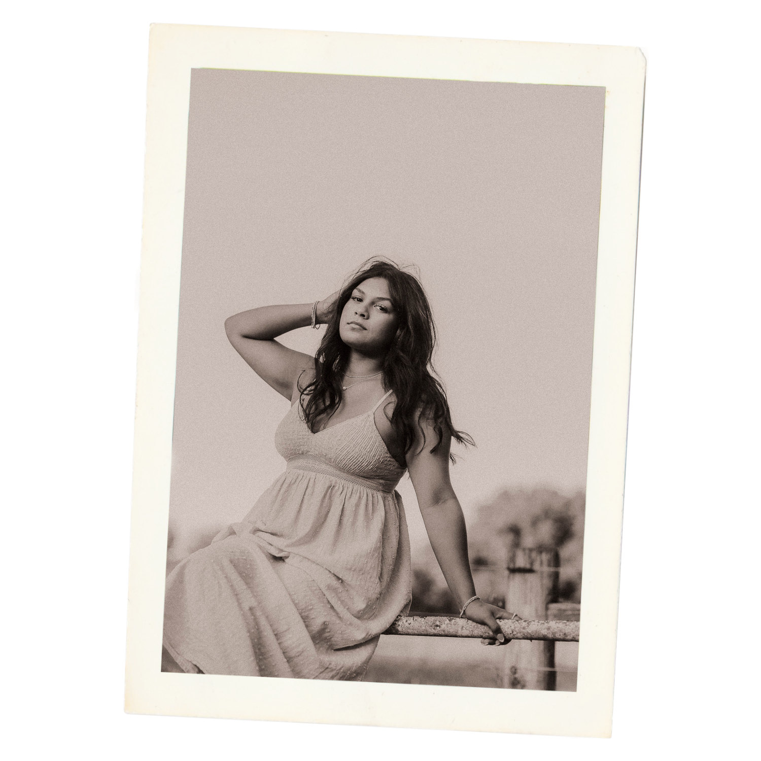 A woman in a flowy white dress poses gracefully in a series of black and white artistic portraits.