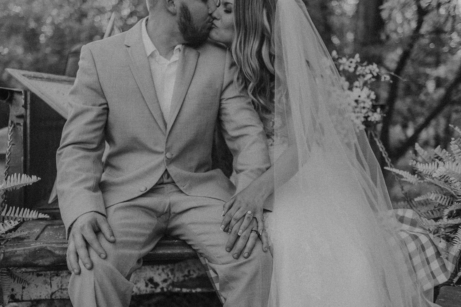 A romantic black and white wedding photo series showing tender moments between newlyweds in an outdoor garden setting.