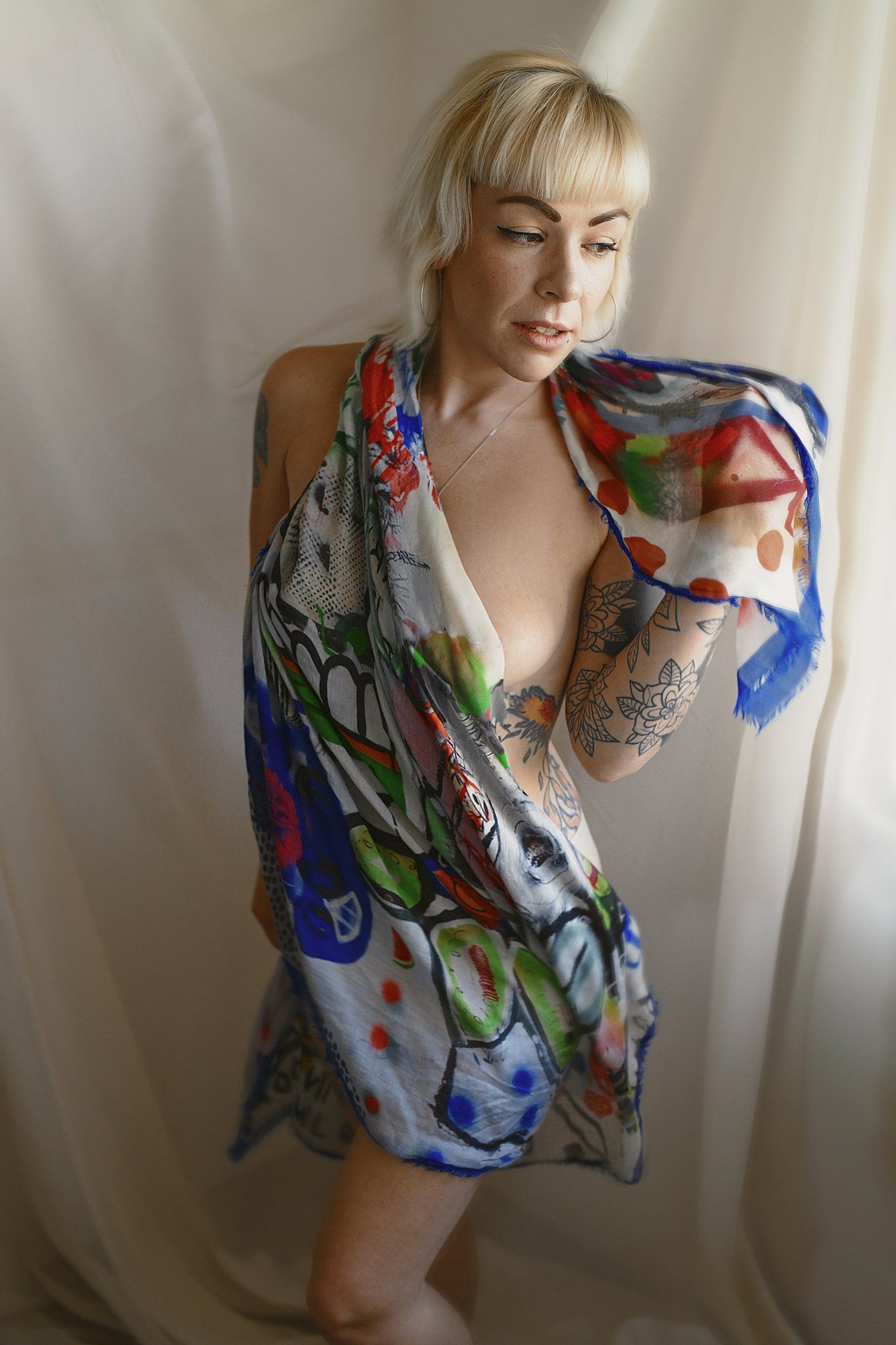 Artistic fashion photo featuring a colorful floral print wrap dress against white fabric backdrop.