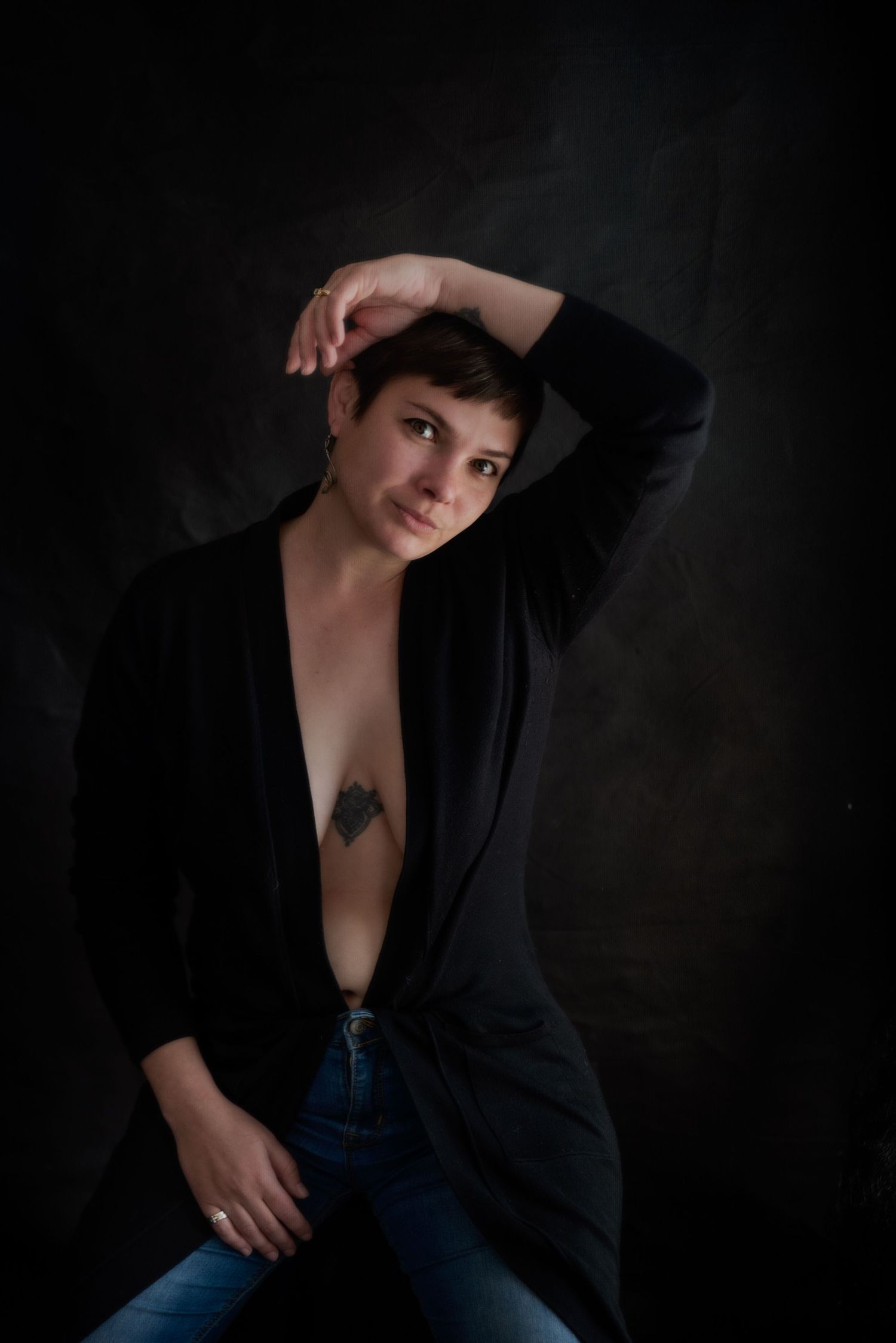 Artistic portrait with dramatic shadows showcasing a black blazer and casual styling.