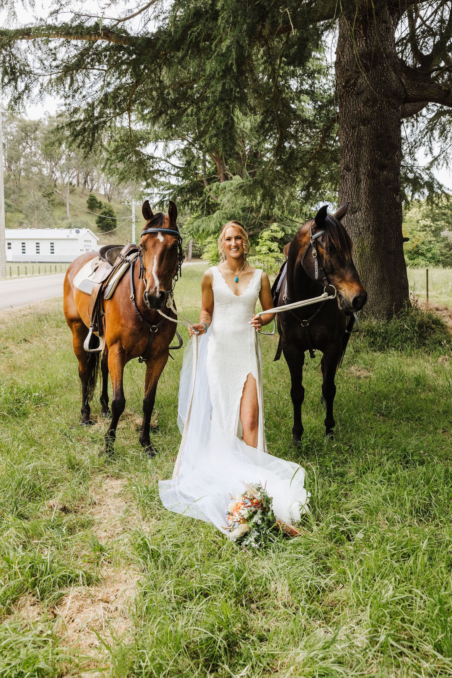 Bridal portraits in a rustic outdoor setting with horses and greenery showcase a romantic wedding day photoshoot.