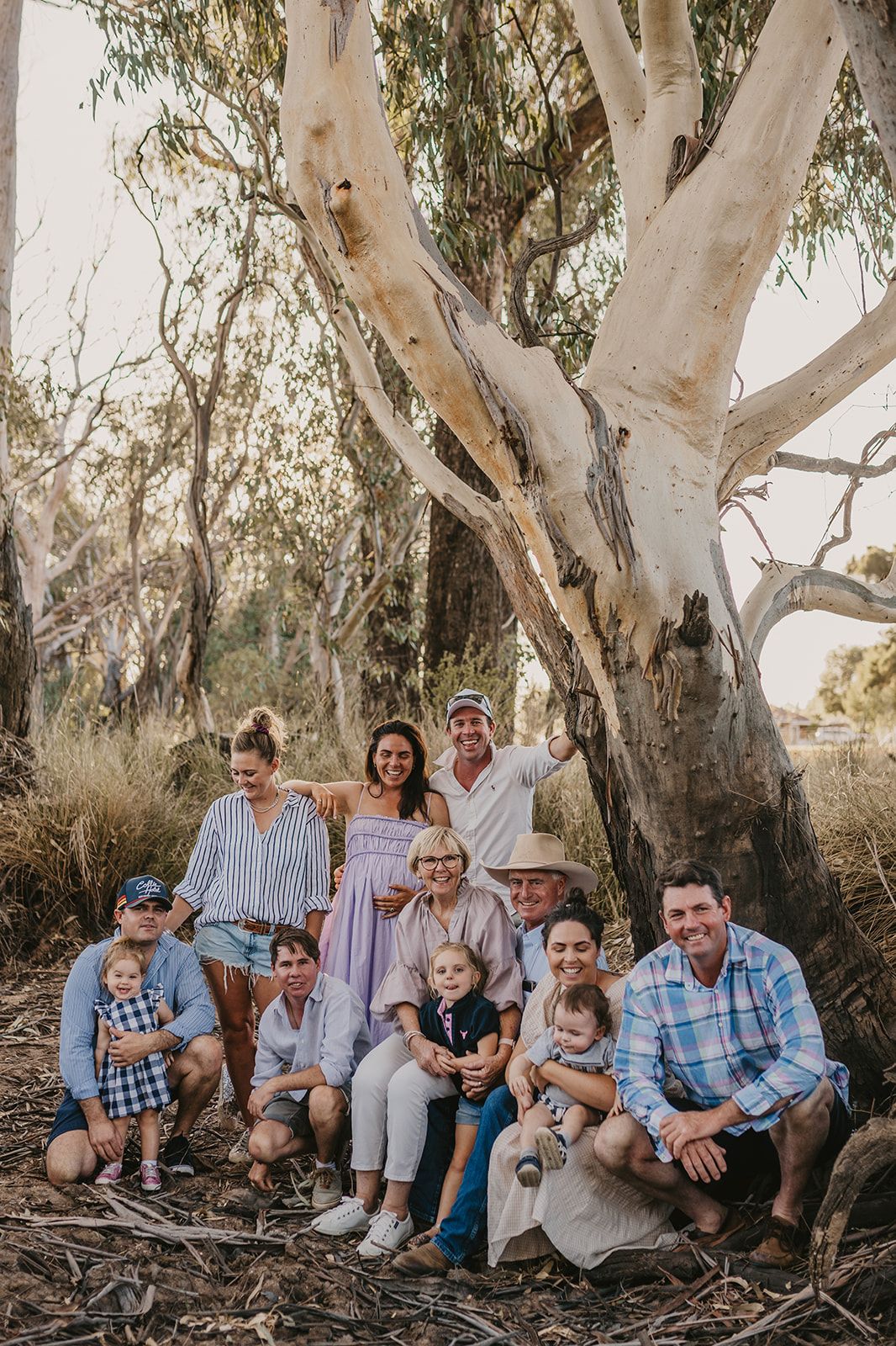 Three generations together, under gum tree, grandparents. parents and grandkids, gathered  near Collie NSW