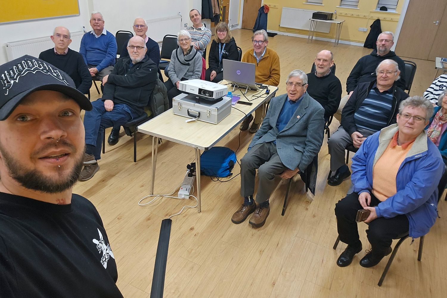 People gathered at tables in a community center for a social event or meeting.