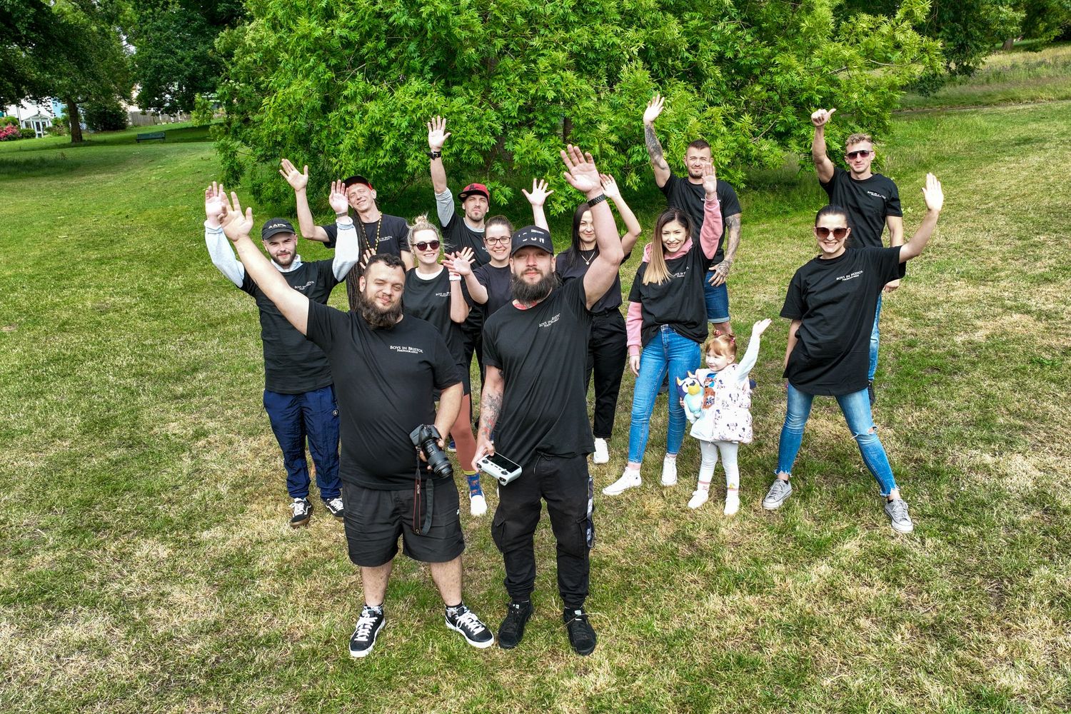Group of people enjoying outdoor activities in a grassy park on a sunny summer day.