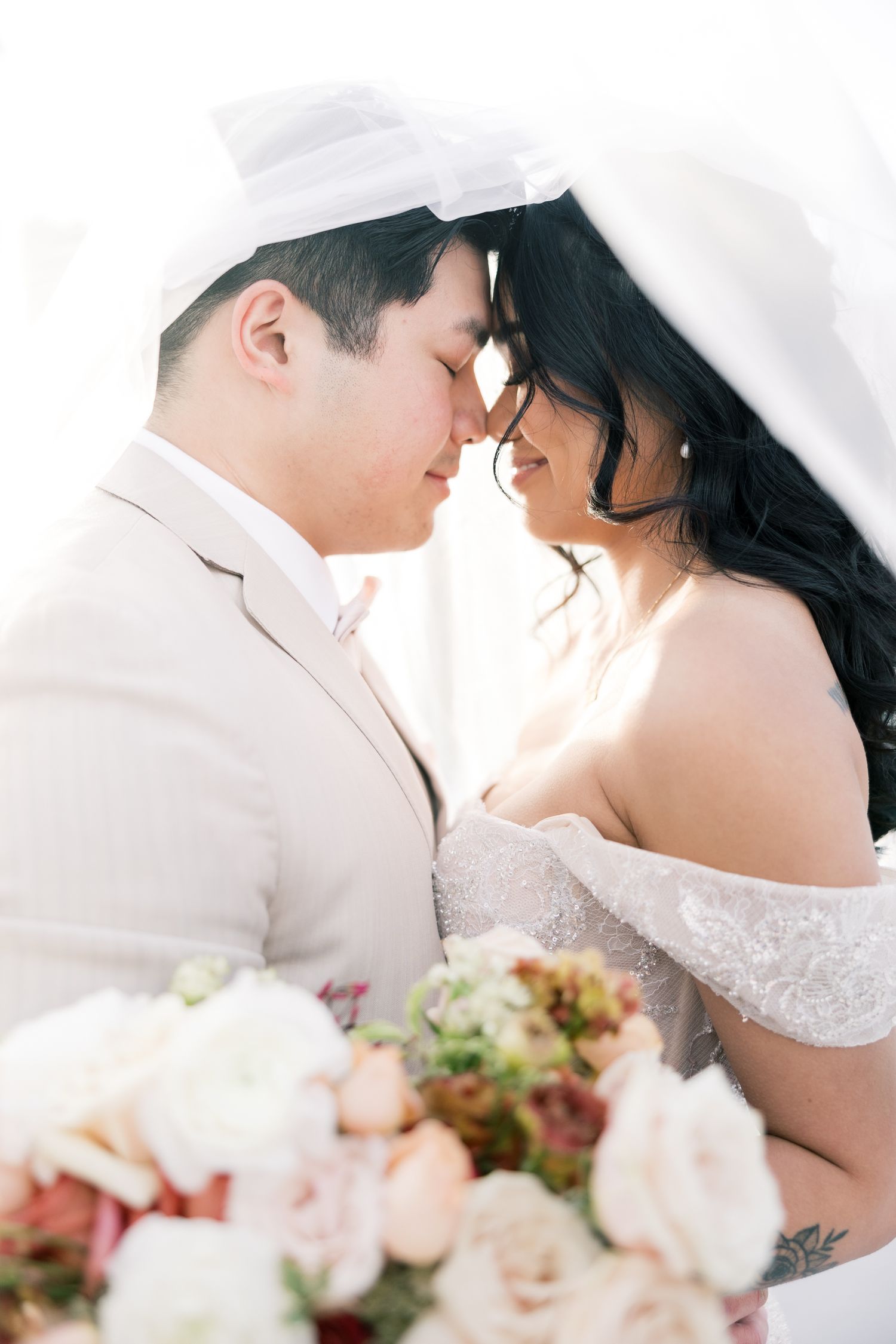 Romantic close-up wedding portraits showing tender moments between newlyweds with soft floral decorations.