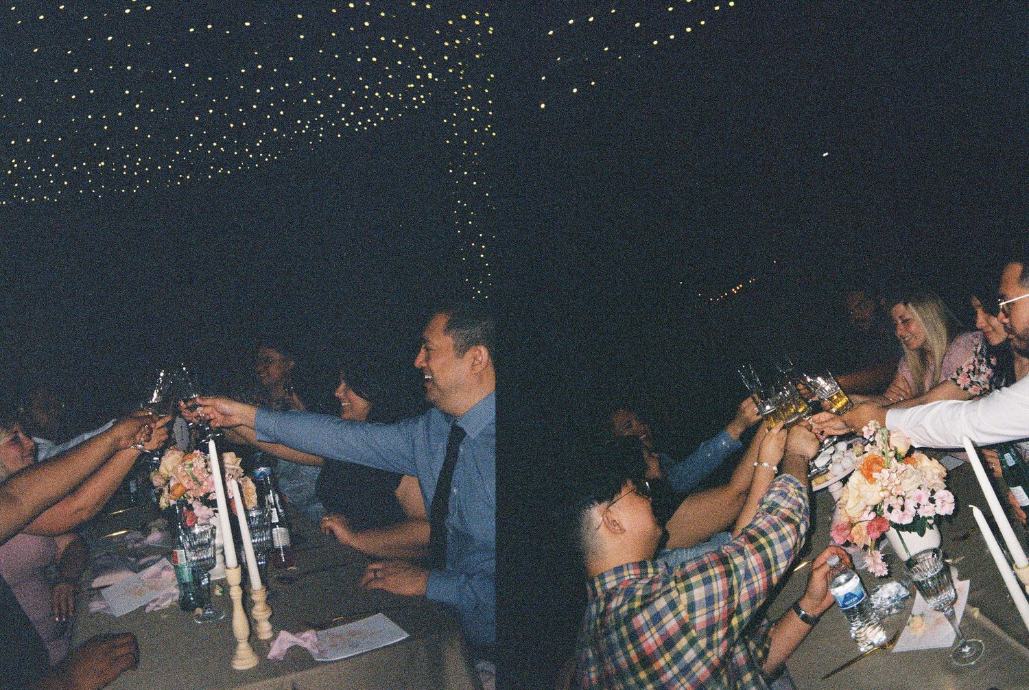 Guests raising glasses in a toast at a dimly lit evening celebration under a starry sky.