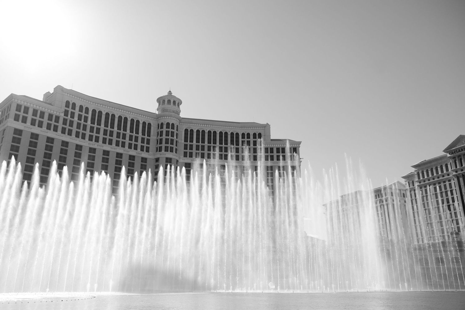 Black and white photo of the Bellagio Hotel fountains shooting water high into the air in Las Vegas.