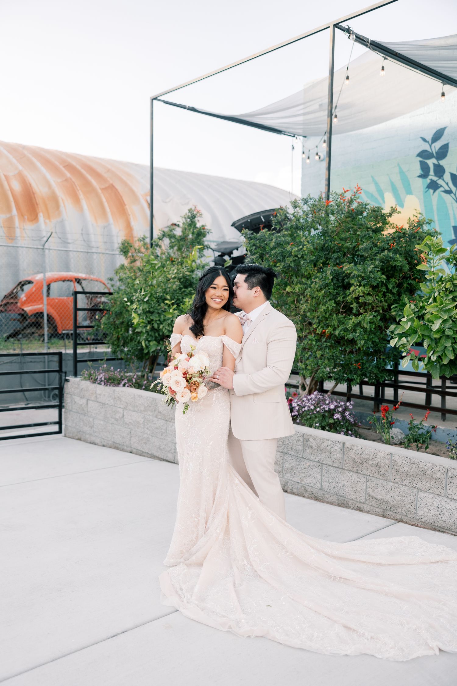 Romantic wedding portraits on a rooftop terrace with greenhouse structures in the background.