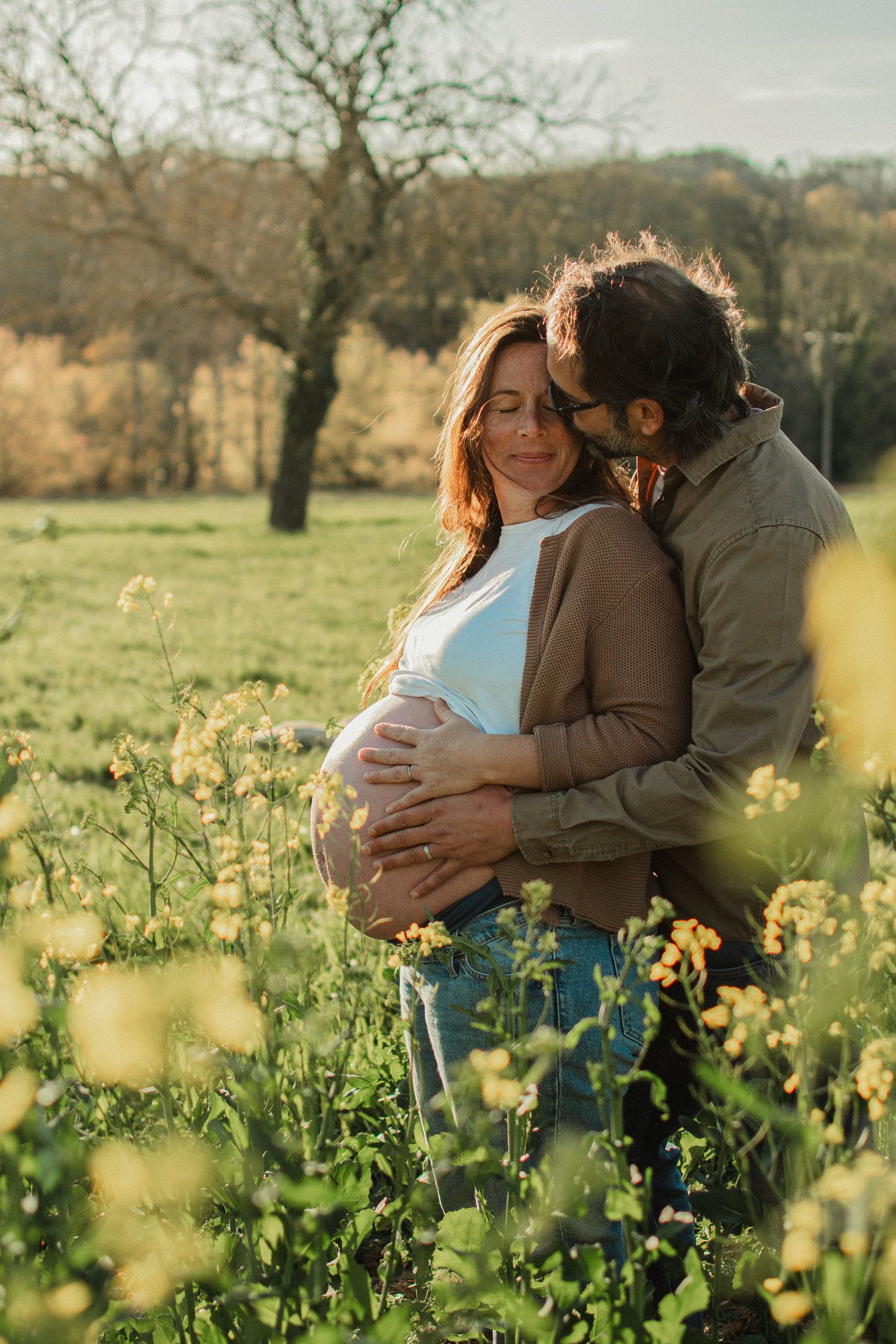 Couple attendant un enfant dans un champ de colza