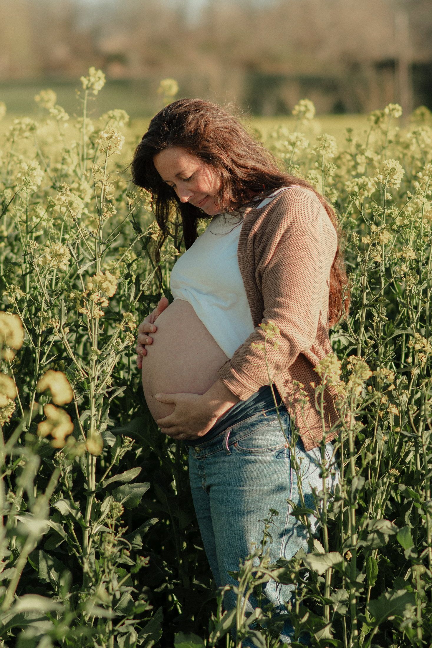 Couple attendant un enfant dans un champ de colza